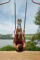 Free photo portrait of man during summertime in 80's aesthetic working out on rings