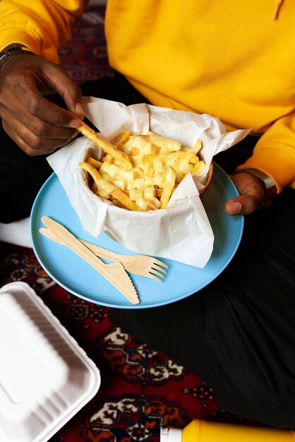 Portrait of man eating a delicious dish of poutine