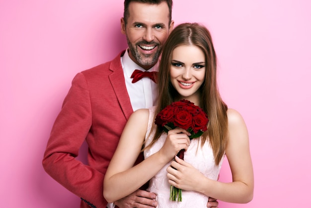 Free photo portrait of man embracing woman with bunch of roses