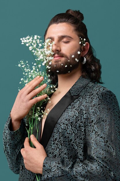 Portrait man in fashionable clothes holding flowers