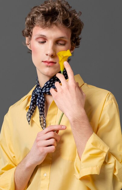 Portrait man in fashionable shirt holding flower