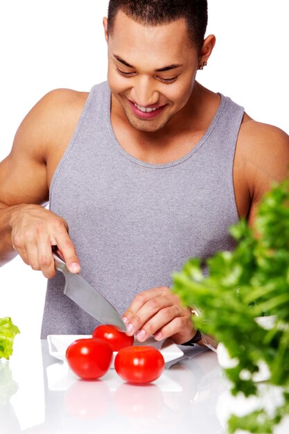 Портрет мужчины в серой рубашке, собирающегося съесть помидор