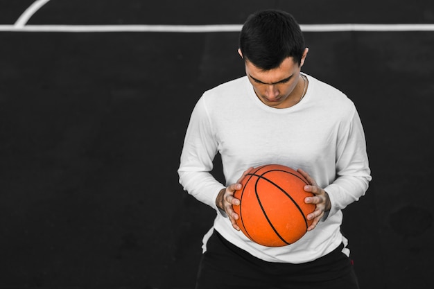 Free photo portrait of man holding basketball