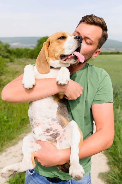 Портрет человека, держащего его собаку на открытом воздухе
