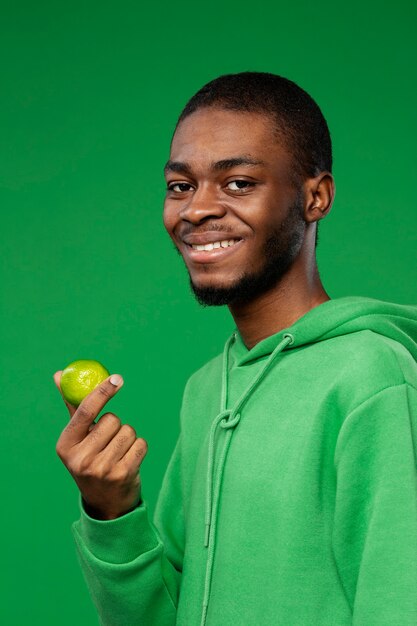 Free photo portrait of man holding lime citrus