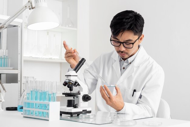 Portrait man in lab working with microscope