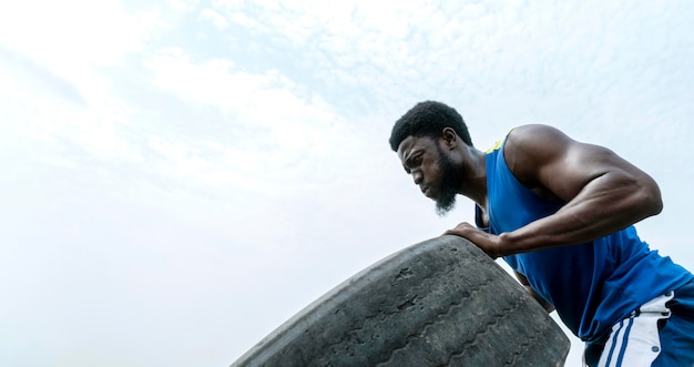 Portrait man in nature lifting truck wheel