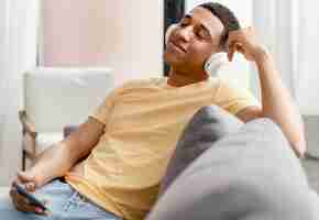 Free photo portrait man relaxing at home while listening music