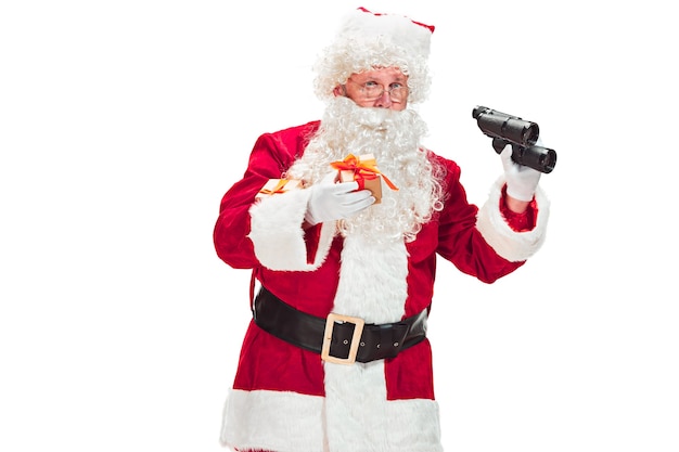 Portrait of Man in Santa Claus Costume - with a Luxurious White Beard, Santa's Hat and a Red Costume - in Full Length isolated on a White Background with binoculars