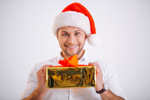 Portrait of man in santa hat holding christmas golden present box