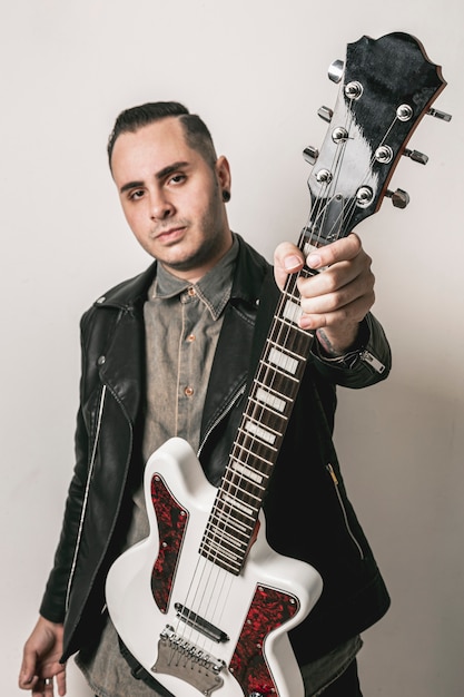 Free photo portrait of man showing electric guitar