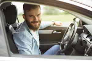 Free photo portrait of man sitting in the car