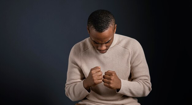 Portrait man sitting with clenched fists