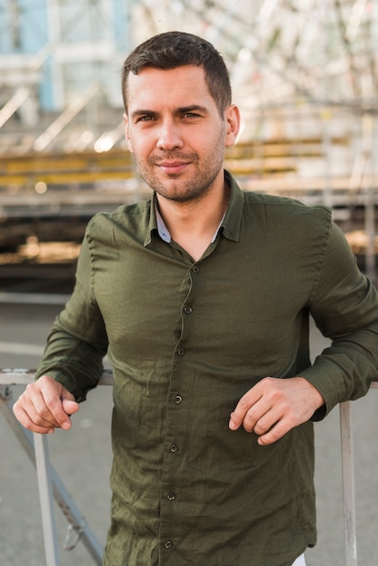 Free photo portrait of man standing in amusement park looking at camera