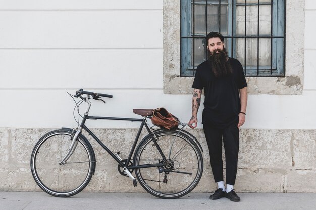 Портрет мужчины с велосипедом на стене