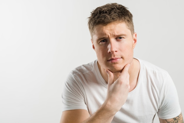 Portrait of a man strokes his chin after shaving against white backdrop