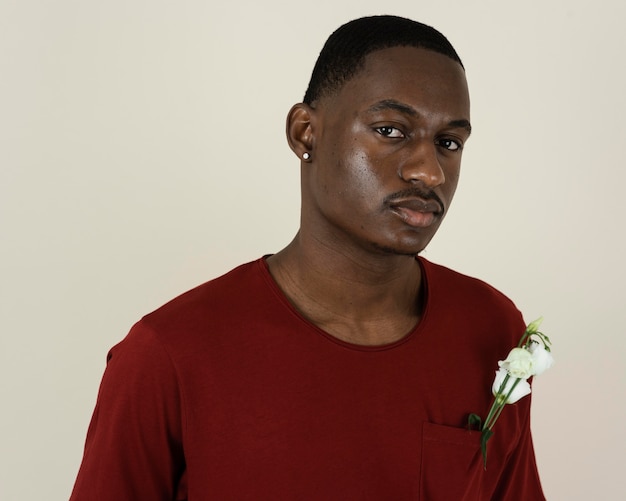 Free photo portrait of man in a t-shirt with flowers in his chest pocket