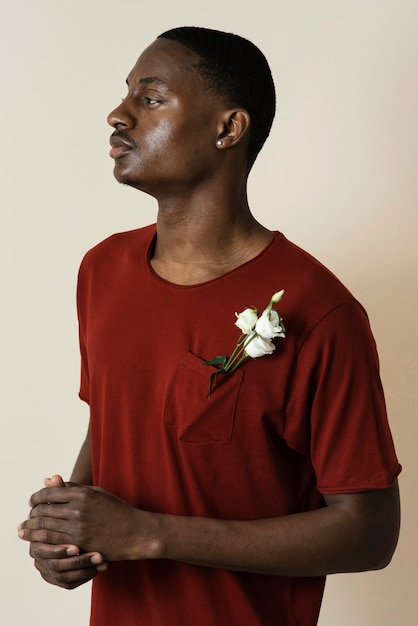 Free photo portrait of man in a t-shirt with flowers in his chest pocket