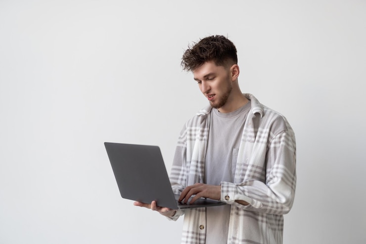 Free Photo portrait of a man using laptop computer over gray background