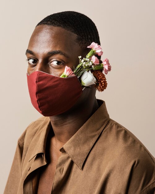 Portrait of man wearing face mask and flowers