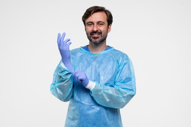 Portrait of man wearing medical gown and gloves