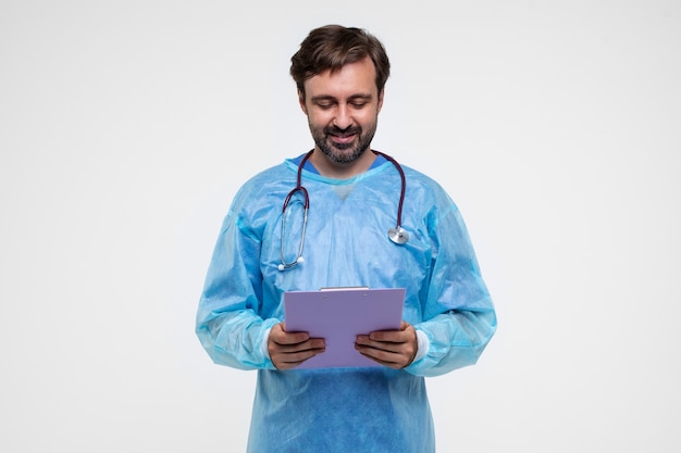 Portrait of man wearing medical gown and holding clipboard