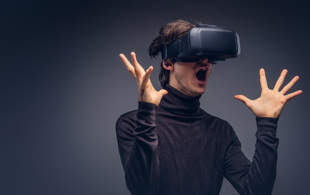 Portrait of a man wearing virtual reality device isolated on a d