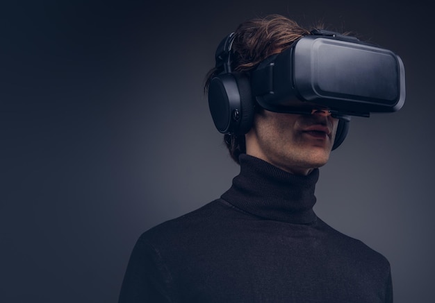 Free photo portrait of a man wearing virtual reality device isolated on a d