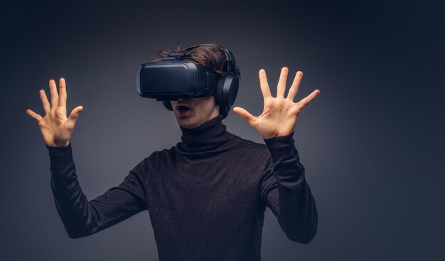 Portrait of a man wearing virtual reality device isolated on a d