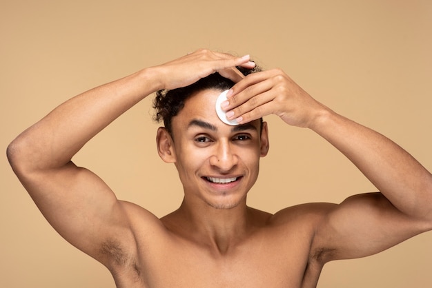 Портрет мужчины, вытирающего лицо салфеткой для макияжа