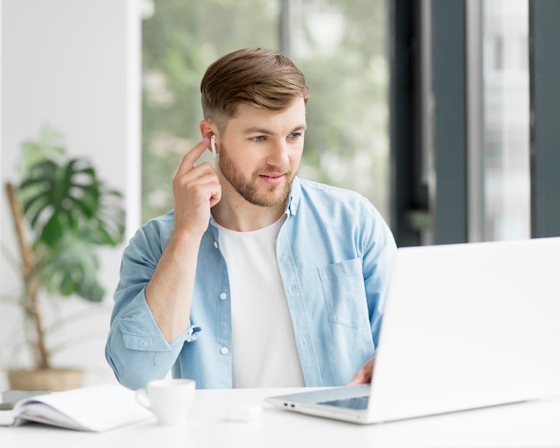 Портрет человека с airpods работает на ноутбуке