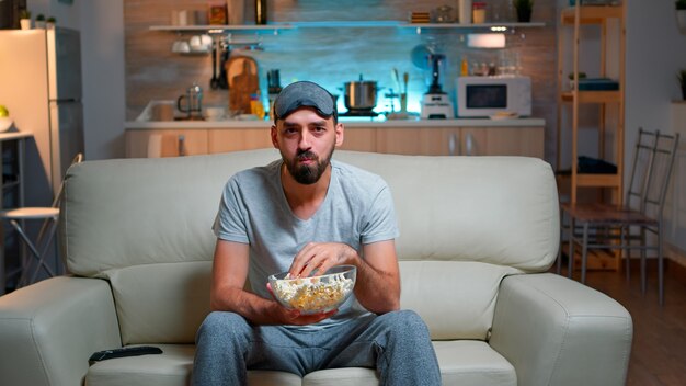 Portrait of man with beard holding popcorn bowl