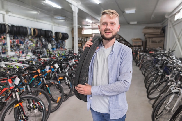 Portrait of a man with bicycle tires in shop