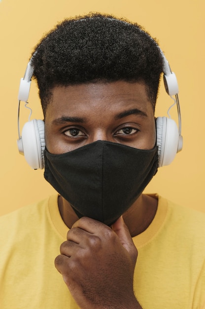 Portrait of man with face mask and headphones