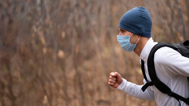 Portrait of man with face mask running in the woods