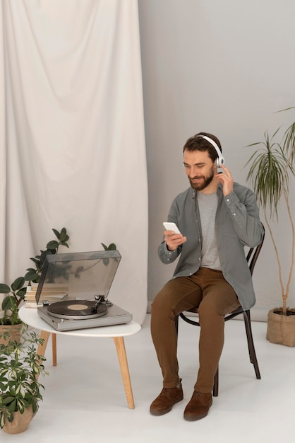 Бесплатное фото Портрет мужчины с наушниками, слушать музыку на мобильном телефоне