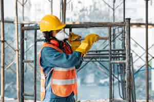 Free photo portrait man with safety equipment side view carrying ladder