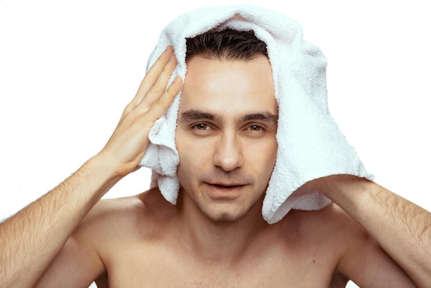 Portrait of man with white bath towel after shower isolated over white studio background