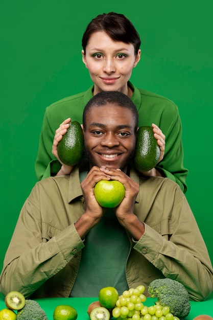 Portrait of man with woman holding green fruits