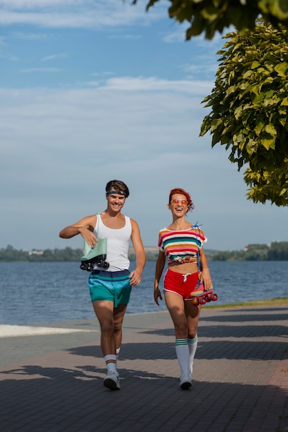 Portrait of man and woman at the beach with roller skates in 80's aesthetic