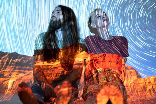 Portrait of man and woman posing with universe projection texture