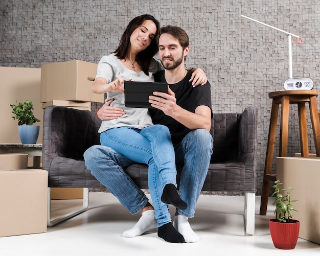 Portrait of man and woman relaxing in new apartment