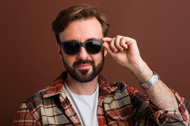 Portrait of manly handsome stylish bearded man on brown