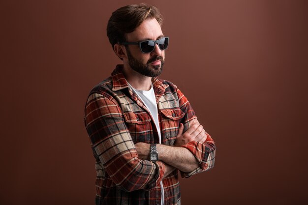 Portrait of manly handsome stylish bearded man on brown