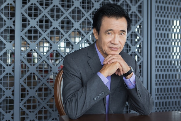 Free photo portrait of mature asian man with hands under chin