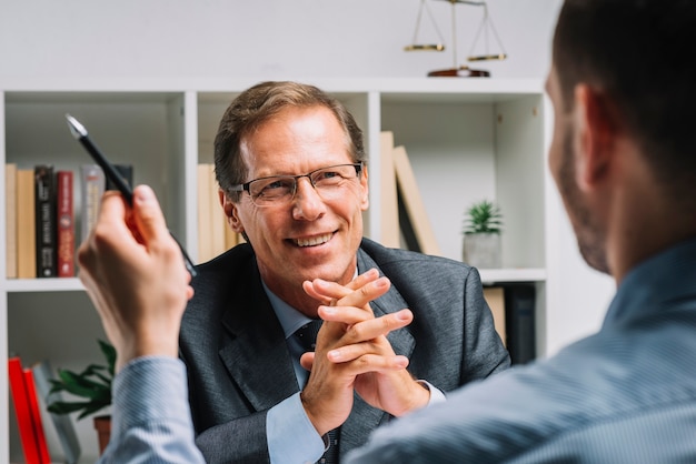 Free photo portrait of mature happy lawyer sitting with client