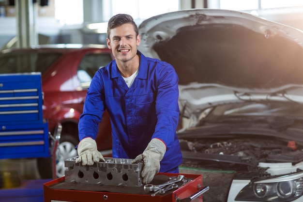 Portrait of mechanic checking a car parts