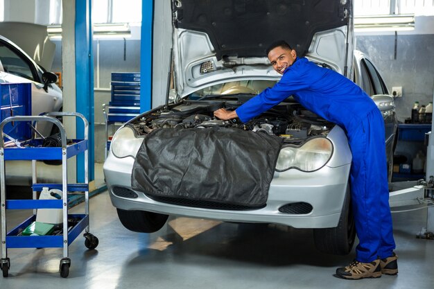 Portrait of mechanic servicing car engine