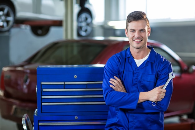 Free photo portrait of mechanic standing with arms crossed