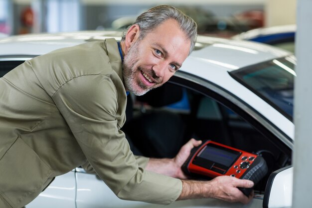 Portrait of mechanic using a diagnostic tool